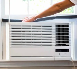 A technician applying black foam insulation to conditioning unit, to seal it as a part of professional window ac repair in Dubai.