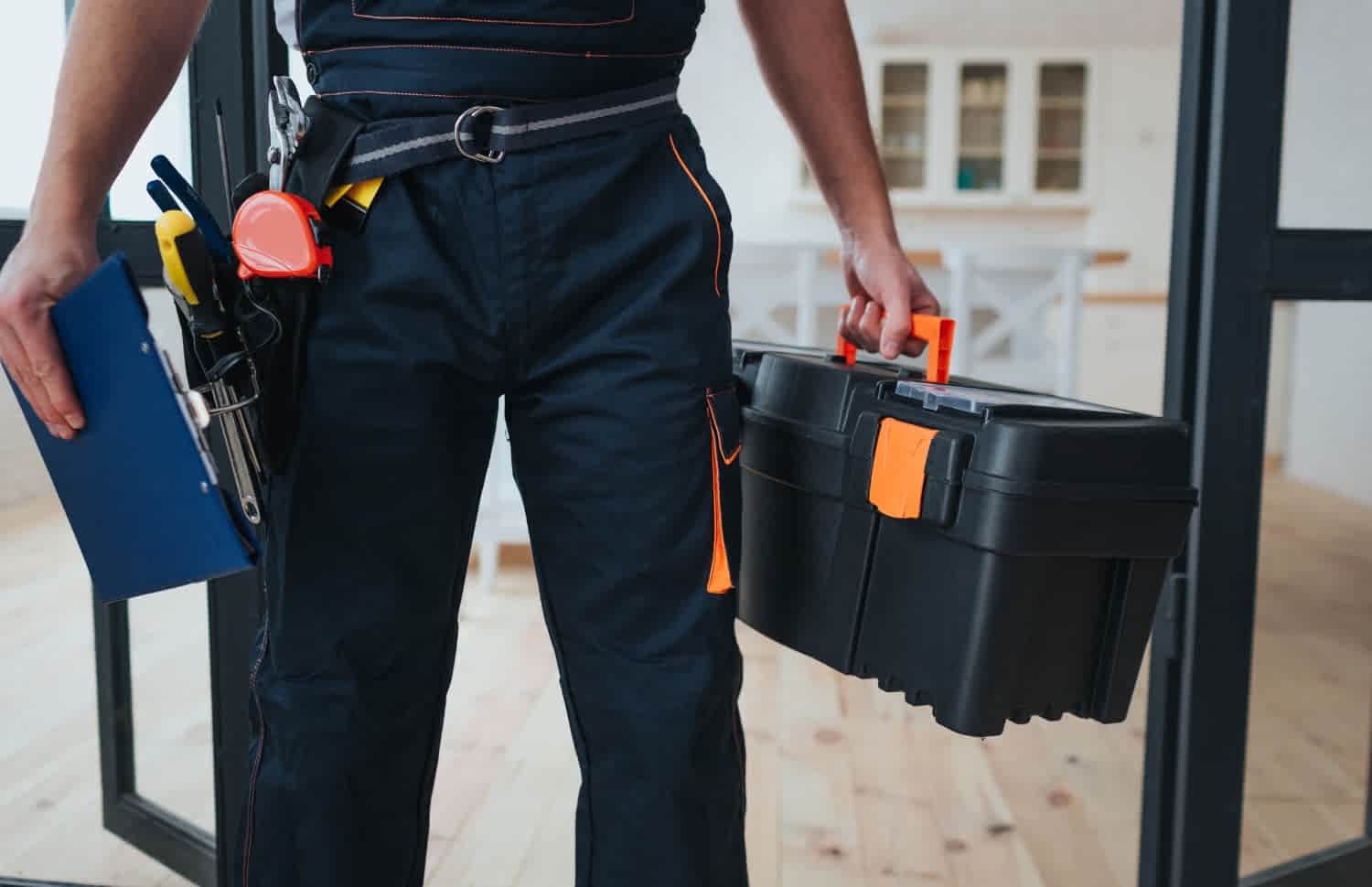 A professional carrying a toolbox and clipboard, about to provide handyman services in Dubai.